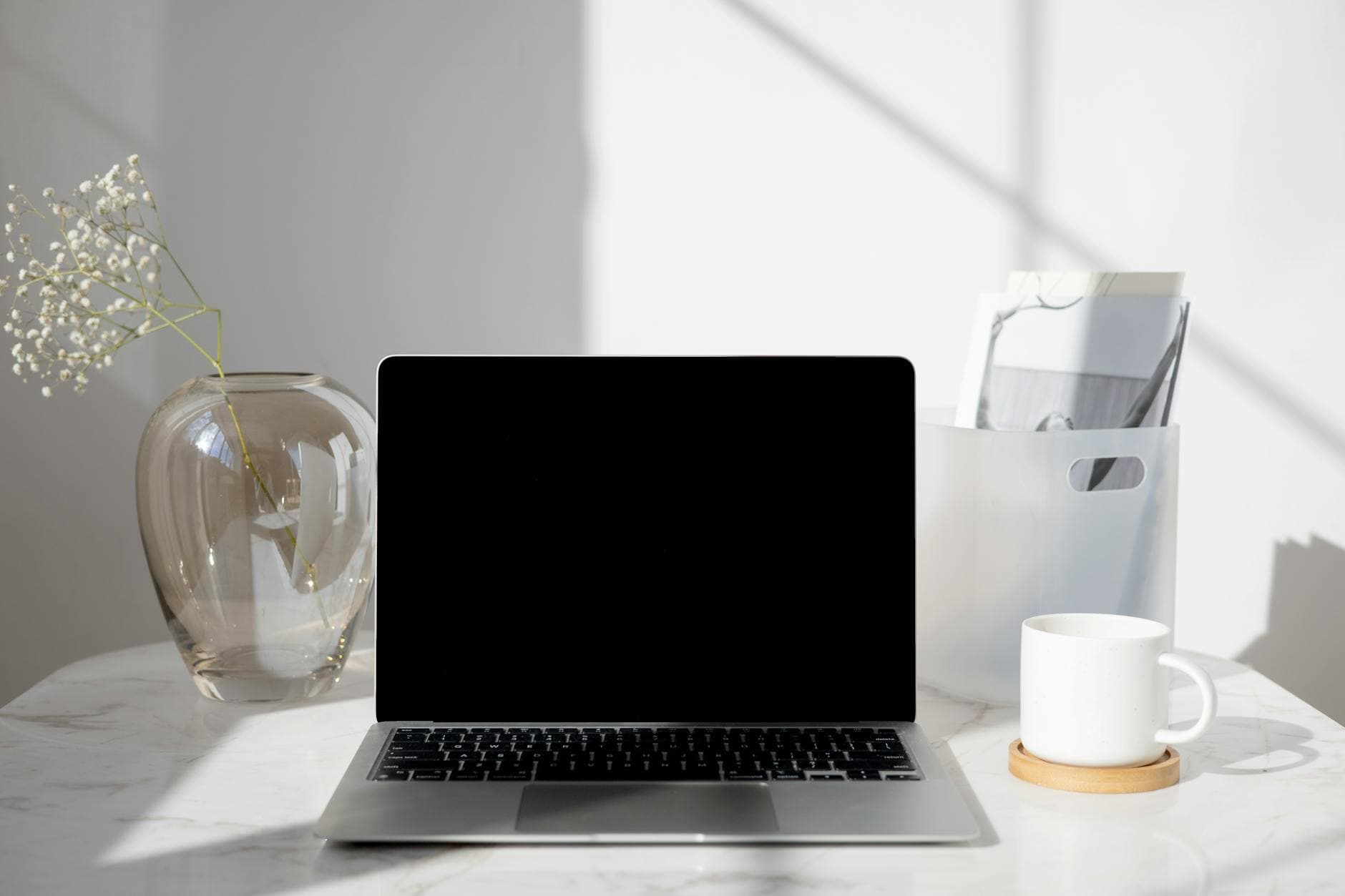 A clean modern workspace with a laptop and notebook