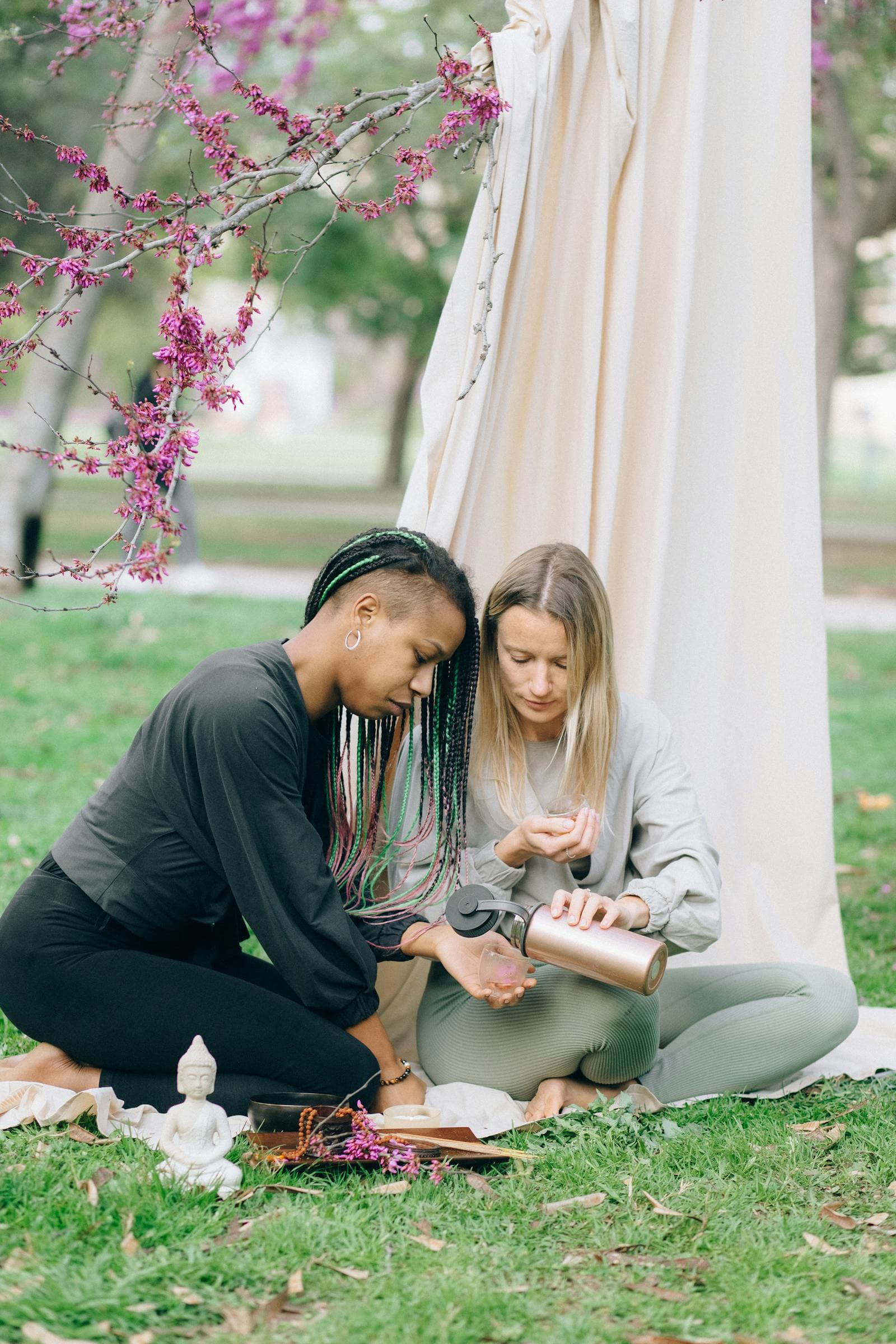 Two women enjoying an outdoor picnic surrounded by nature
