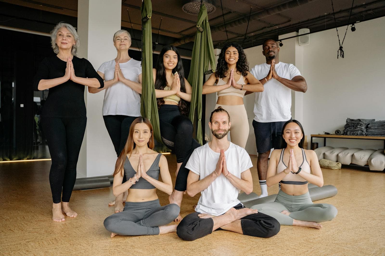 A multicultural group practicing yoga together in a bright studio
