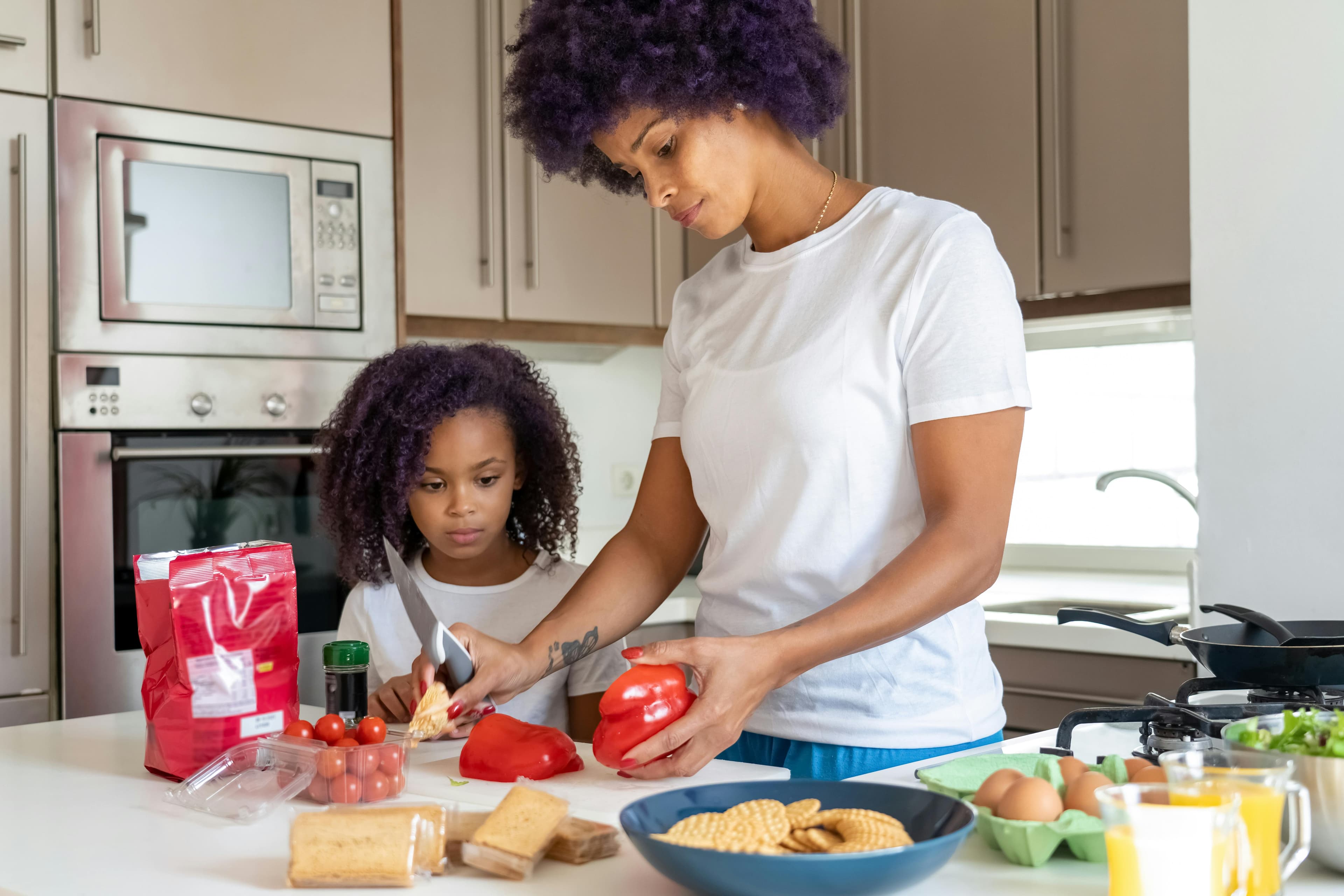 A parent and child preparing food together