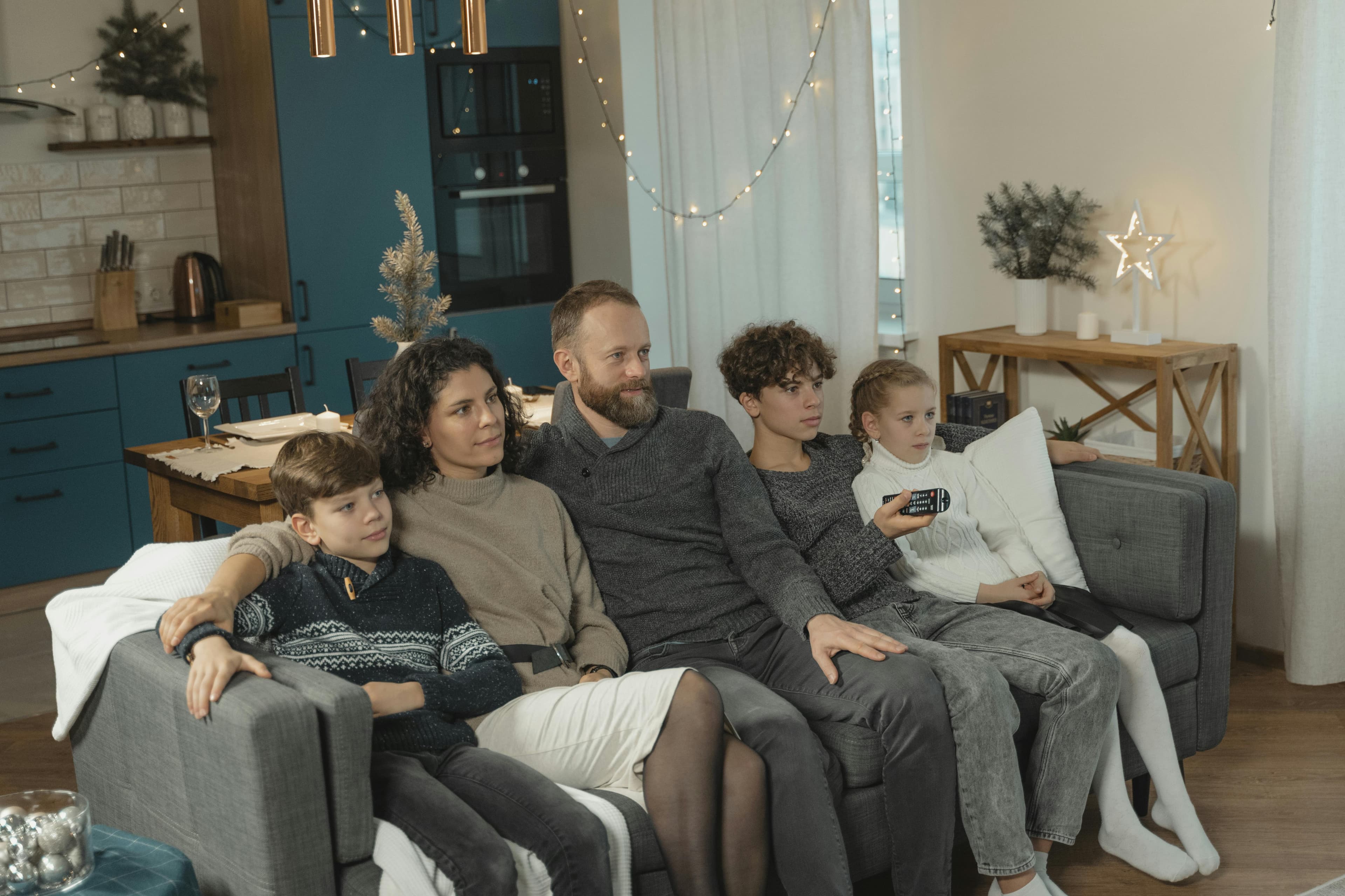 A family on a couch in evening lighting, mid-conversation