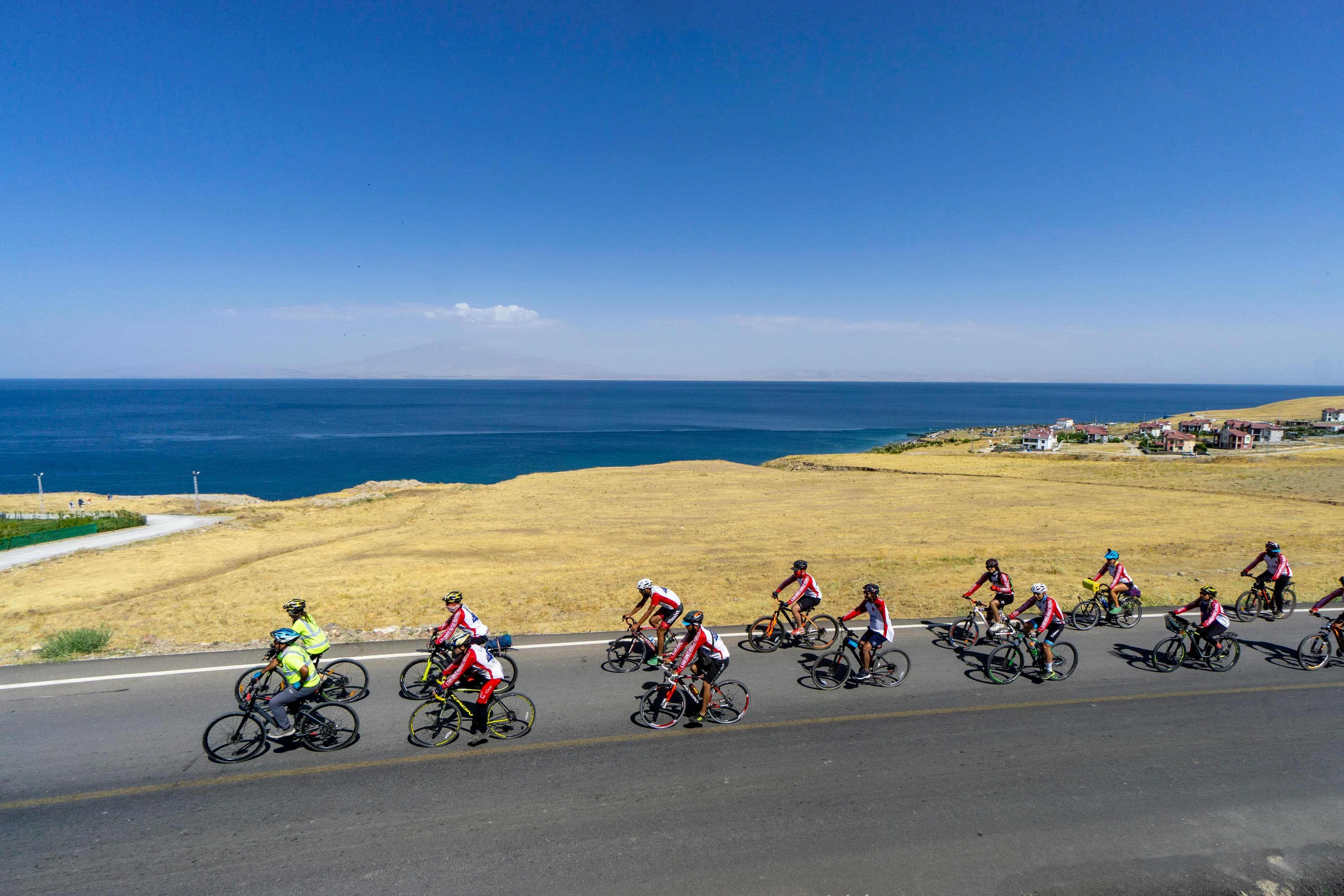 A cyclist on a coastal road, helmet visible