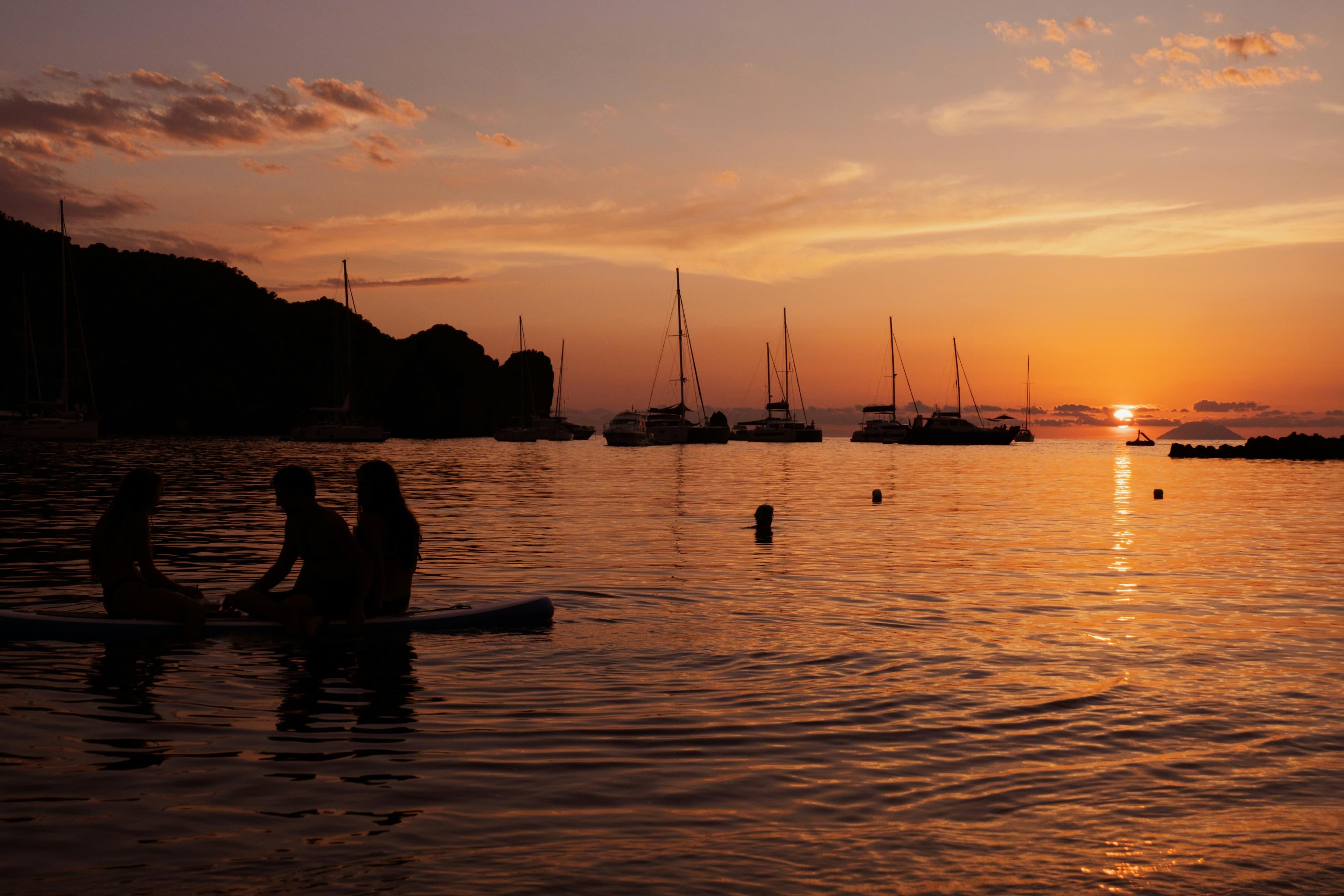 A person on a stand-up paddleboard at sunrise