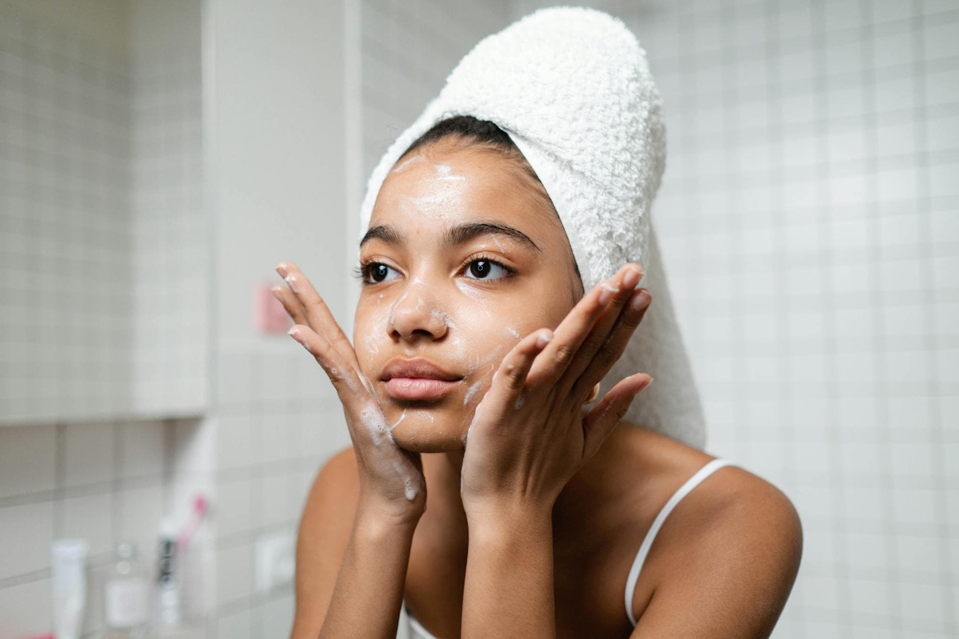 A face cleanser bottle on a bathroom tile counter